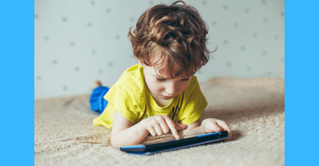 young boy playing with tablet